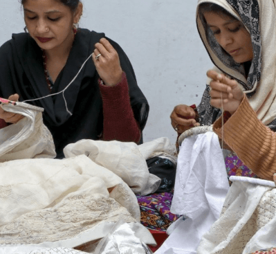 Chikankari artisans working on intricate embroidery patterns, showcasing the dedication and patience required for this delicate craft.
